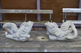 A pair of reconstituted stone dolphin water features.