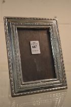 An embossed silver photograph frame, photo size 4.¾" x 3¼".