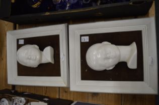 A pair of unusual pottery busts, framed.
