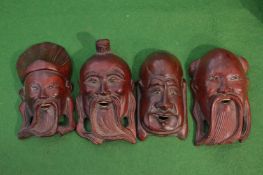 Four small Japanese carved wood masks.
