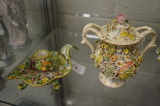 A Continental porcelain floral encrusted chamber stick and a similar vase and cover.