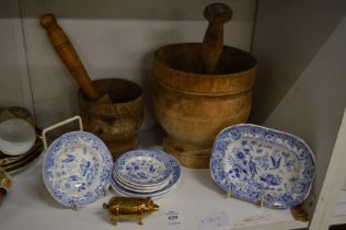 A child's blue and white part service, brass pig and two wooden pestle and mortars.