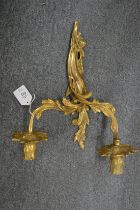An ormolu twin branch wall light, decorative trays and a mirror.