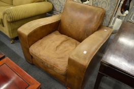 A large modern brown leather upholstered armchair.