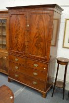 A George III mahogany linen press with pair of panel doors enclosing four sliding trays above a base