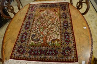 A small silk Persian tree of life rug.