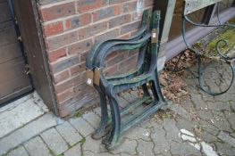 A pair of heavy cast iron bench ends with matching centre support.