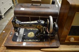 An old Serata sewing machine, a Bush radio, an old pitch fork and long handled window opener.