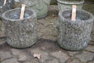 A pair of reconstituted stone planters.