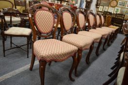A good set of six Victorian carved walnut dining chairs with upholstered backs and seats.