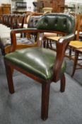 A green leather upholstered desk chair.