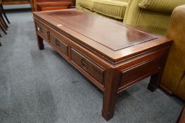 A Chinese red wood three drawer coffee table.