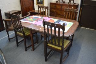An oak drop-leaf gateleg dining table and four oak dining chairs.