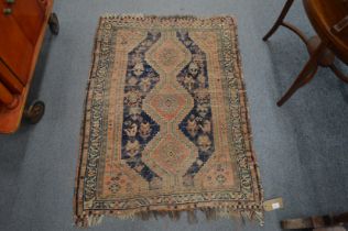 A small Persian rug (moth damage and worn) 115cm x 87cm.