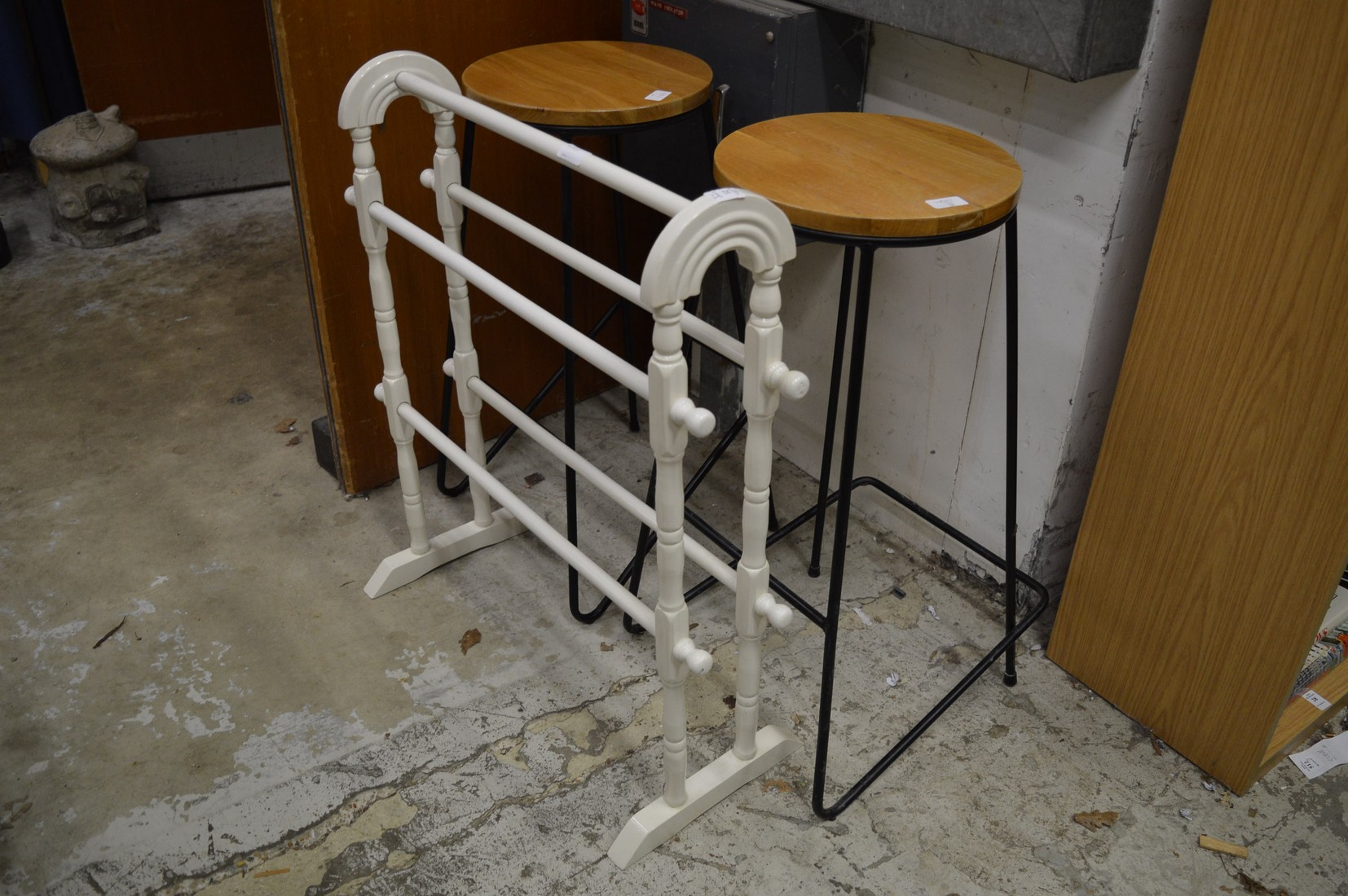A painted towel rail and a pair of stools.