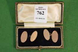 A pair of 9 carat gold oval shaped cufflinks with engine turned decoration.