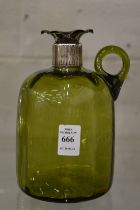 A green glass decanter with silver mounts (lacking stopper).