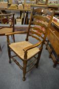 A rush seated ladder back carver chair and three side chairs.