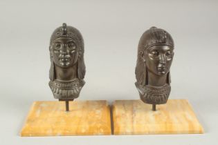 A SMALL PAIR OF EGYPTIAN BRONZE HEADS, on Sienna marble bases.