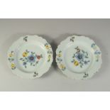 A PAIR OF FLORAL TIN GLAZED PLATES. 9ins diameter.