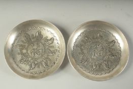 A PAIR OF CHINESE WHITE METAL COIN DISHES. 3.25ins diameter.