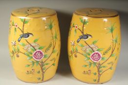 A PAIR OF CHINESE YELLOW GROUND BARREL SEATS painted with birds and flowers. 17ins high.