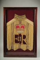 AN E. R. ROYAL COACHMAN'S TUNIC in a glass case. 26ins x 16ins.