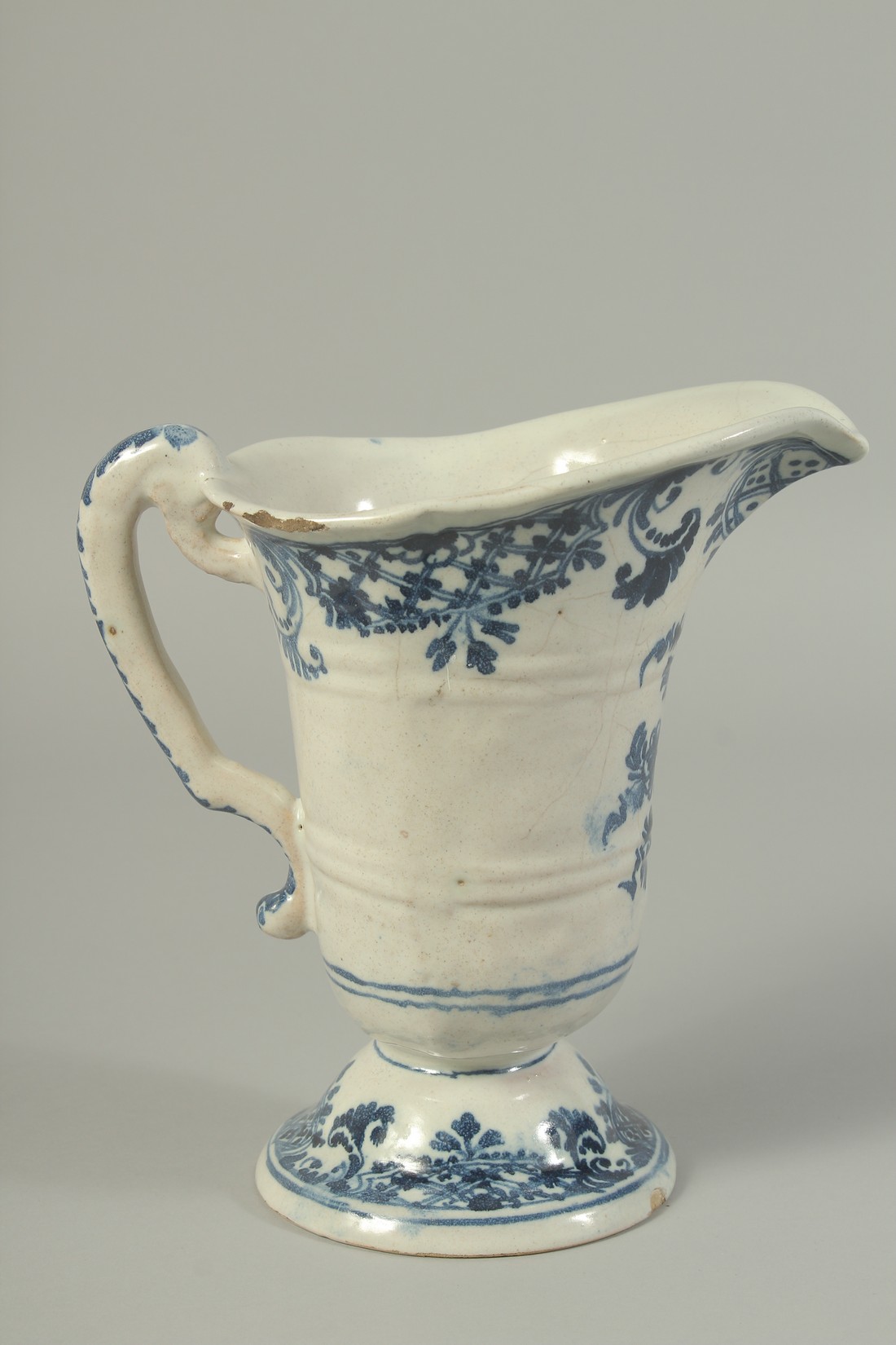 AN 18TH CENTURY ROUEN BLUE AND WHITE DELFT PATTERN JUG with carrying handle. 8ins high.