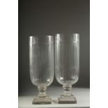 A PAIR OF CUT GLASS HURRICANE LAMPS on square bases. 16ins high.