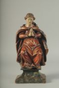 A GOOD 17TH - 18TH CENTURY CARVED WOOD AND PAINTED PRAYING FIGURE on a plinth. 16ins high.
