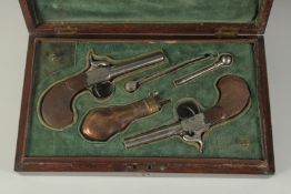 A CASED PAIR OF POCKET PERCUSSION PISTOLS with checkered butts and shell carving in the French
