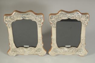 A PAIR OF SILVER PHOTOGRAPH FRAMES with butterfly design. 8ins x 6ins.