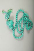 A STRING OF TURQUOISE BEADS AND PENDANT.