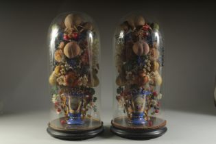 A VERY GOOD PAIR OF VICTORIAN GLASS DOMES, WAX FRUIT in a vase. 23ins overall.