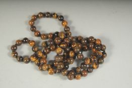 A STRING OF TIGER'S EYE BEADS. 38ins long.