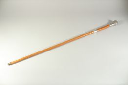 A BAMBOO CANE with a silver handle. 37ins high,