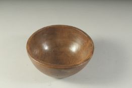 AN EARLY WOODEN CIRCULAR BUTTER BOWL AND SPOON. 6.5ins diameter.