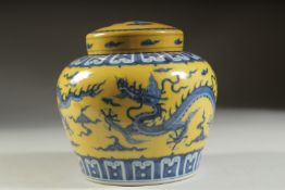 A YELLOW GROUND BLUE AND WHITE DRAGON GINGER JAR AND COVER, 14cms high.
