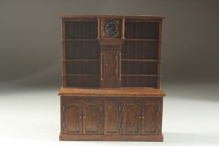 A GOOD 18TH DESIGN OAK MINIATURE WELSH DRESSER, the top with three shelves either side of a clock,