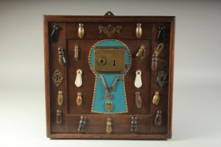 A COLLECTION OF ESCUTCHEONS AND KEYS, mounted on a frame. 17ins x 17ins.