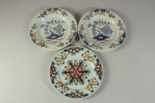 A PAIR OF TIN GLAZE FLORAL PLATES and another similar. 9ins diameter (3).