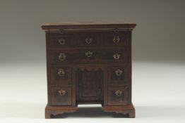 A SUPERB QUALITY GEORGE 1ST DESIGN WALNUT KNEEHOLE DESK with crossbanded top, three short and a long