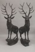 AFTER JULES MOIGNIEZ. A MASSIVE PAIR OF BRONZE STAGS standing on rocky bases. 6ft 6ins high.