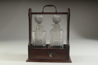 A TANTALUS with two cut glass decanters and stopppers.