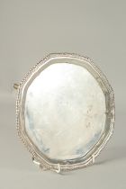 A SILVER PIE CRUST SALVER with gadrooned edge, on four pad feet, 8ins diameter. Birmingham, 1912.