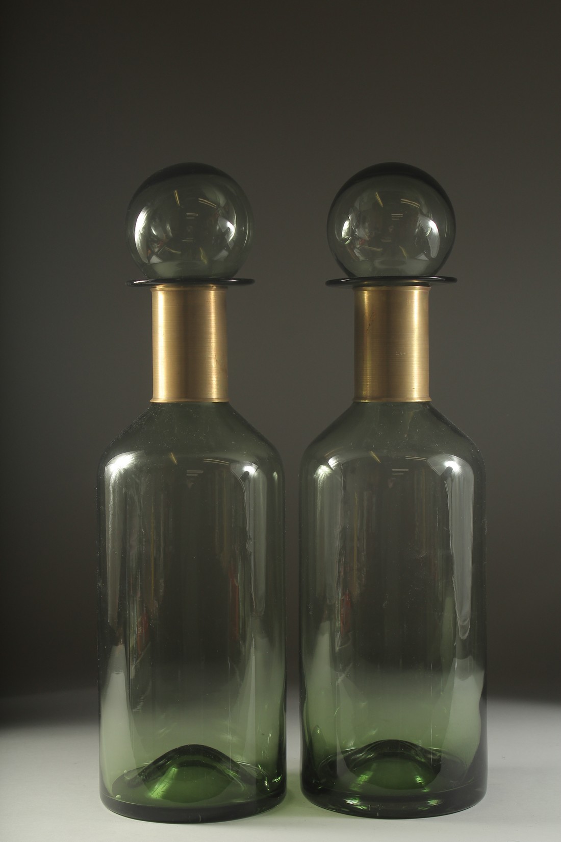 A PAIR OF GREEN GLASS CHEMIST'S BOTTLES. 17ins high.