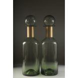 A PAIR OF GREEN GLASS CHEMIST'S BOTTLES. 17ins high.