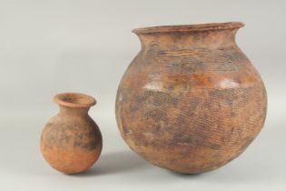 A LARGE AFRICAN BROWN POTTERY POT. 11ins and another pot, 5ins. (2)