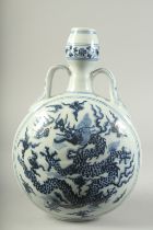 A CHINESE BLUE AND WHITE TWIN HANDLE MOON FLASK painted with a large dragon. 33cms high.