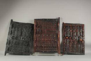 THREE EARLY AFRICAN CARVED WOOD DOORS. 20ins x 13ins.